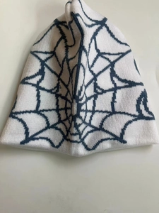 Macro detail of the white and blue spider web jacquard pattern on the knitted beanie hat