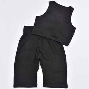 Vista piatta del set sportivo in maglia a coste nera con top corto e pantaloncini a vita alta