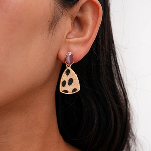 Detail view of retro earrings with purple studs and leopard print triangle pendants
