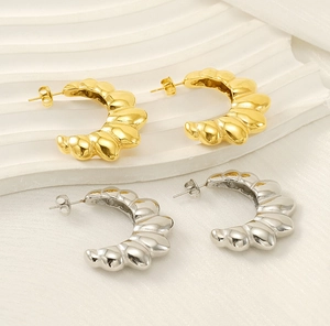 Detail view of gold and silver C-shaped scallop textured stainless steel earrings