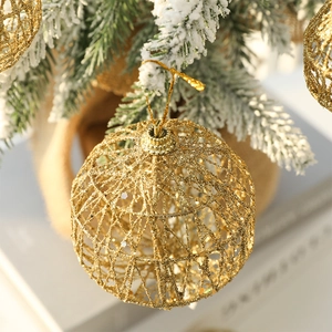 Golden glitter mesh Christmas ball ornament hanging on a snowy tree for festive decor