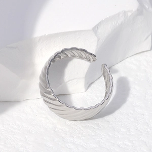 Minimalist silver ripple textured open ring made of stainless steel on white stone
