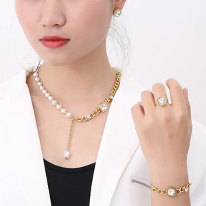 Close-up of golden pearl jewelry set with zircon necklace, earrings, ring and bracelet
