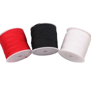 Three spools of red, black, and white braided cord for jewelry making and DIY crafts