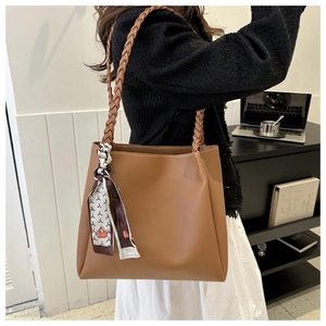 Brown PU leather tote bag detail with woven handle and geometric print scarf accent