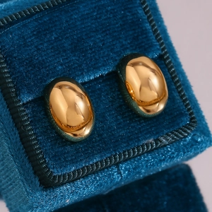 Dettaglio di orecchini a perno ovali placcati oro 18K in scatola portagioie in velluto blu
