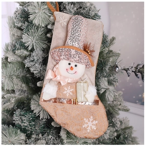 Detail of Christmas stocking with snowman doll and sequins hanging on a tree