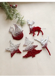 Detail of red and silver flocked Christmas ornaments featuring reindeer and tree shapes