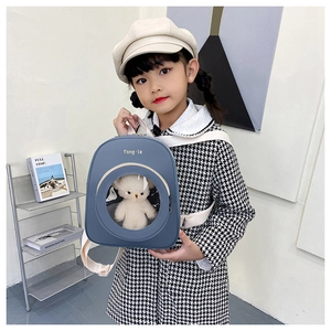 Close-up of kids backpack with transparent window and plush bear doll inside
