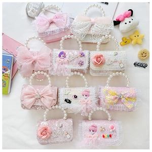 Detailed macro of girls pearl handle bag with lace bow and tweed texture finish