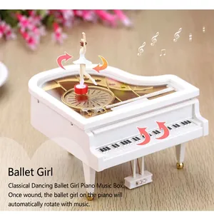 Macro detail of dancing ballerina figure spinning on white piano musical box lid