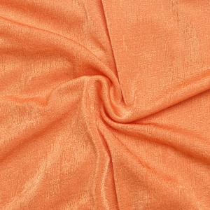 Macro texture of orange woven fabric with soft sheen and layered draping folds
