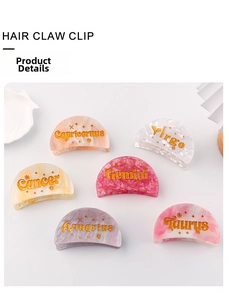 Close-up of semi-circular acrylic hair clips with zodiac patterns and gold star details