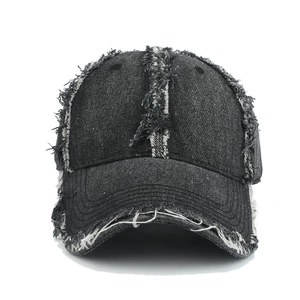 Macro detail of frayed edges and vintage distressed texture on denim baseball cap