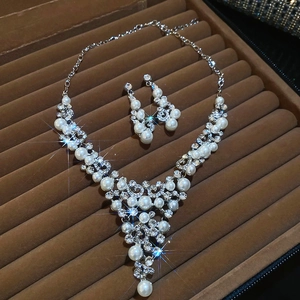 Détail d'un ensemble bijoux fleur perle et strass dans un coffret en velours brun