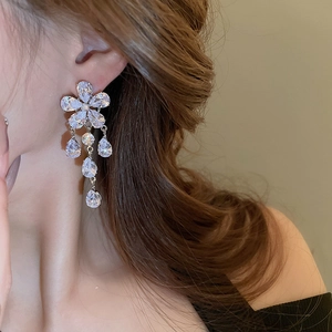 Close-up of silver flower earrings with water drop tassels on female model