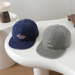 Détail de casquettes en coton délavé olive et marine avec texte brodé élégant