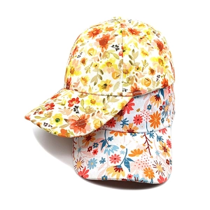 Detail view of two floral baseball caps in yellow and blue-orange cotton canvas fabric