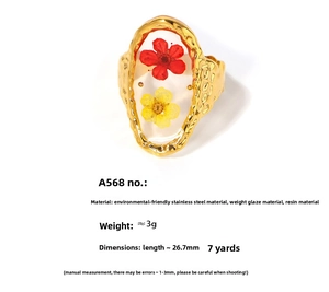 Detail of vintage gold ring with real dried flowers embedded in clear resin oval