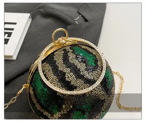 Detail of spherical evening bag with tricolor sequins and gold metal ring handle