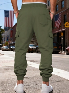 Rear view of army green cargo jogger pants showing large side pockets and elastic cuffs