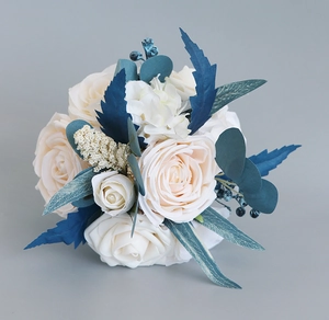 Close-up of bridal bouquet with cream roses, blue berries and forest-style foliage