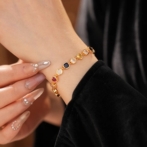 Gros plan d'un bracelet vintage doré avec zircons multicolores en forme de cœur et ronds