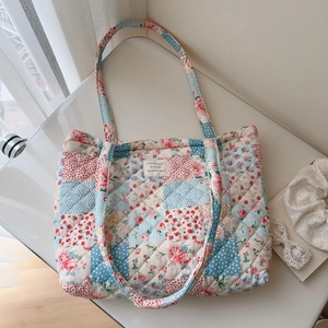 Close-up of quilted patchwork floral tote bag with French label and lace details