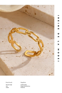 Detailed view of golden link chain ring on stone texture with soft shadows