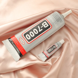 B7000 clear jewelry glue in 110ml and 3ml sizes on soft pink silk fabric background
