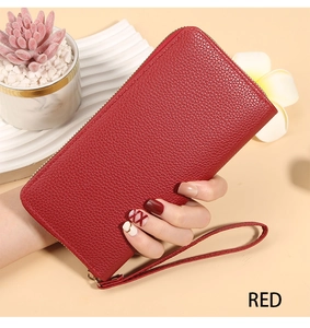 Detailed view of red lychee textured long wallet with matching wrist strap and zipper