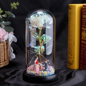 Detail of colorful galaxy rose with LED lights and couple figurines in glass dome