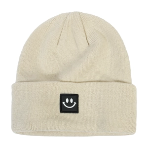 Close-up of beige ribbed knit beanie with a square black smiley face woven patch