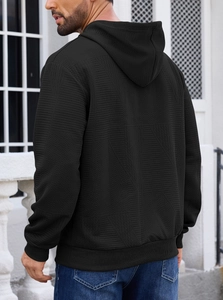 Detailed side view of black men's hoodie featuring thick textured jacquard waffle fabric