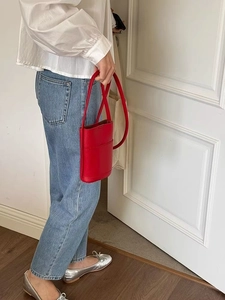 Minimalist red leather mini crossbody phone bag with long strap shown on a model