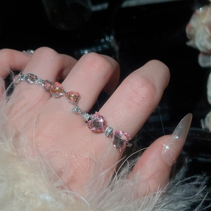 Close-up of sparkling pink heart-shaped crystal rings set on a silver metal base