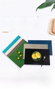 Détail de divers sets de table en PVC tissé résistants à la chaleur et texturés