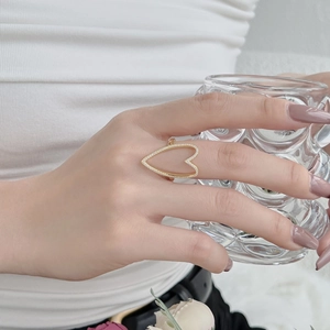 S925 sterling silver hollow heart ring with clear zircons worn in stylish indoor setting