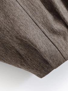 Detailed macro view of the brown herringbone tweed fabric texture on bomber jacket