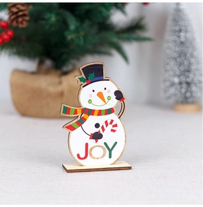 Detail of wooden snowman Christmas ornament featuring a festive JOY sign and candy cane