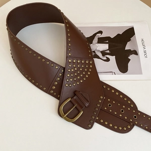 Detail of vintage brown leather belt with dense bronze studs and aged golden buckle