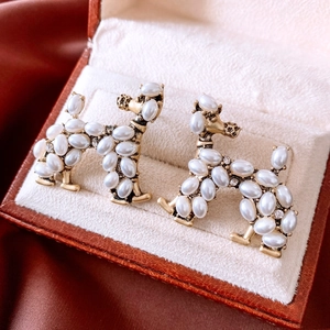 Close-up of vintage gold poodle earrings with pearls and crystals in a velvet jewelry box