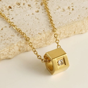 Macro view of 18k gold plated hexagon necklace with square zircon stone detail