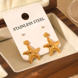 Détail d'un ensemble de boucles d'oreilles étoile de mer dorées et clous en zircon en bois