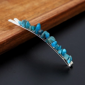 Close-up of a silver hair clip featuring irregular blue natural crystal stones texture