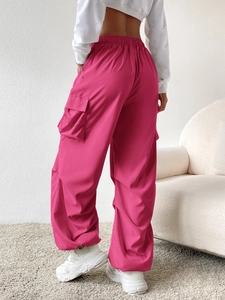 Detail of high-waisted fuchsia cargo pants with elastic drawstring waist and side pockets