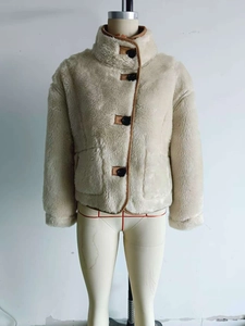 Detail of warm fleece jacket featuring large black buttons and faux leather trim