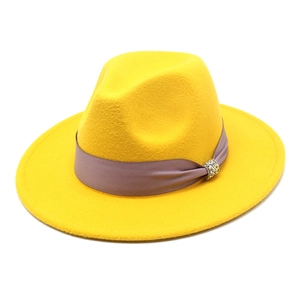 Detail of yellow wool fedora hat featuring a lavender ribbon and rhinestone buckle