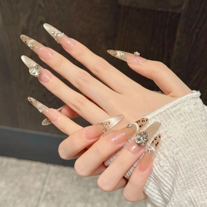 Detailed view of almond-shaped press-on nails with maple leopard print and rhinestones