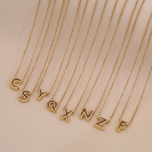 Gold plated 26 letter pendant necklaces with cubic zirconia inlays on a fine curb chain